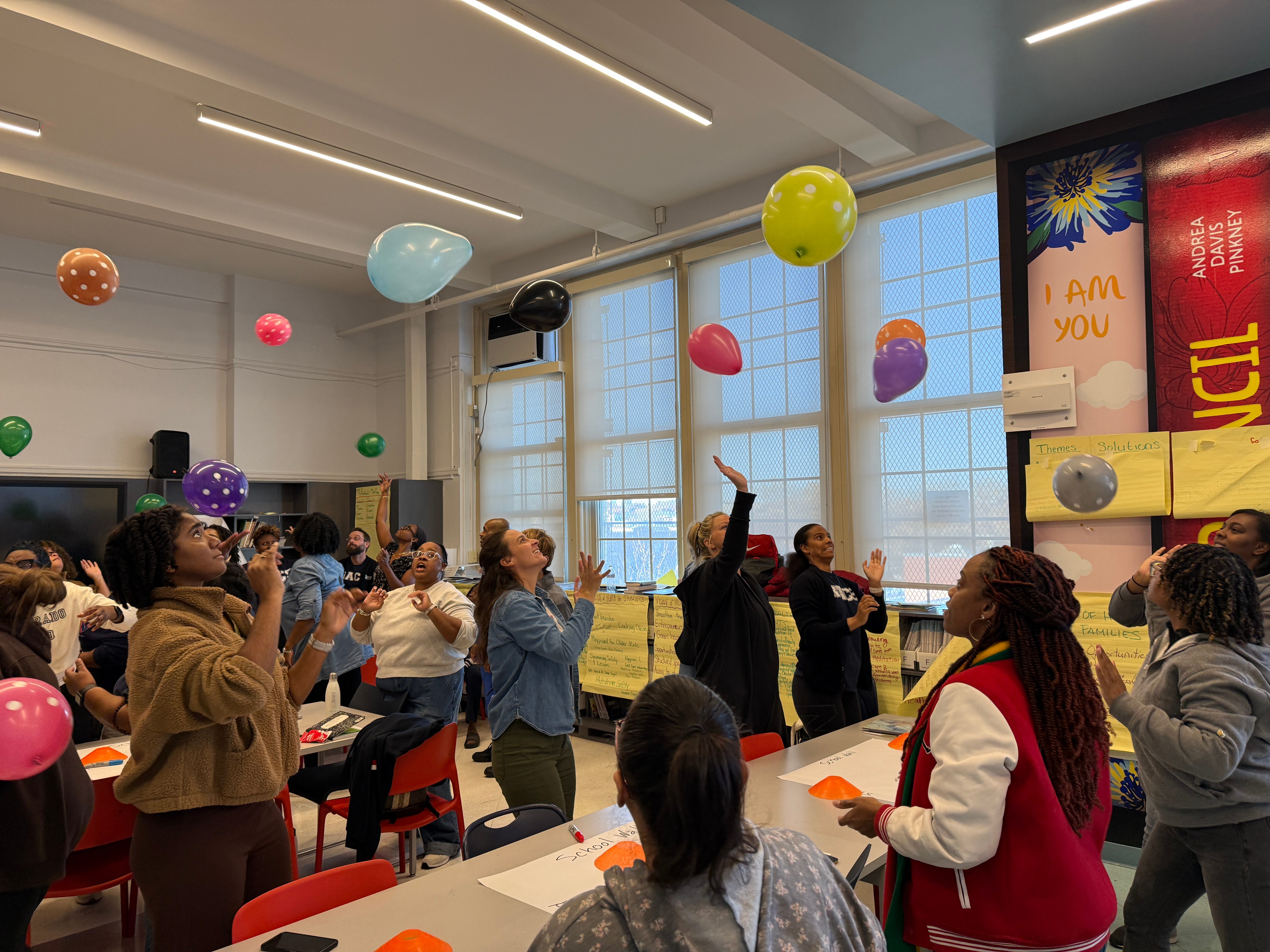Students actively engaged in movement-based learning with colorful balloons in classroom
