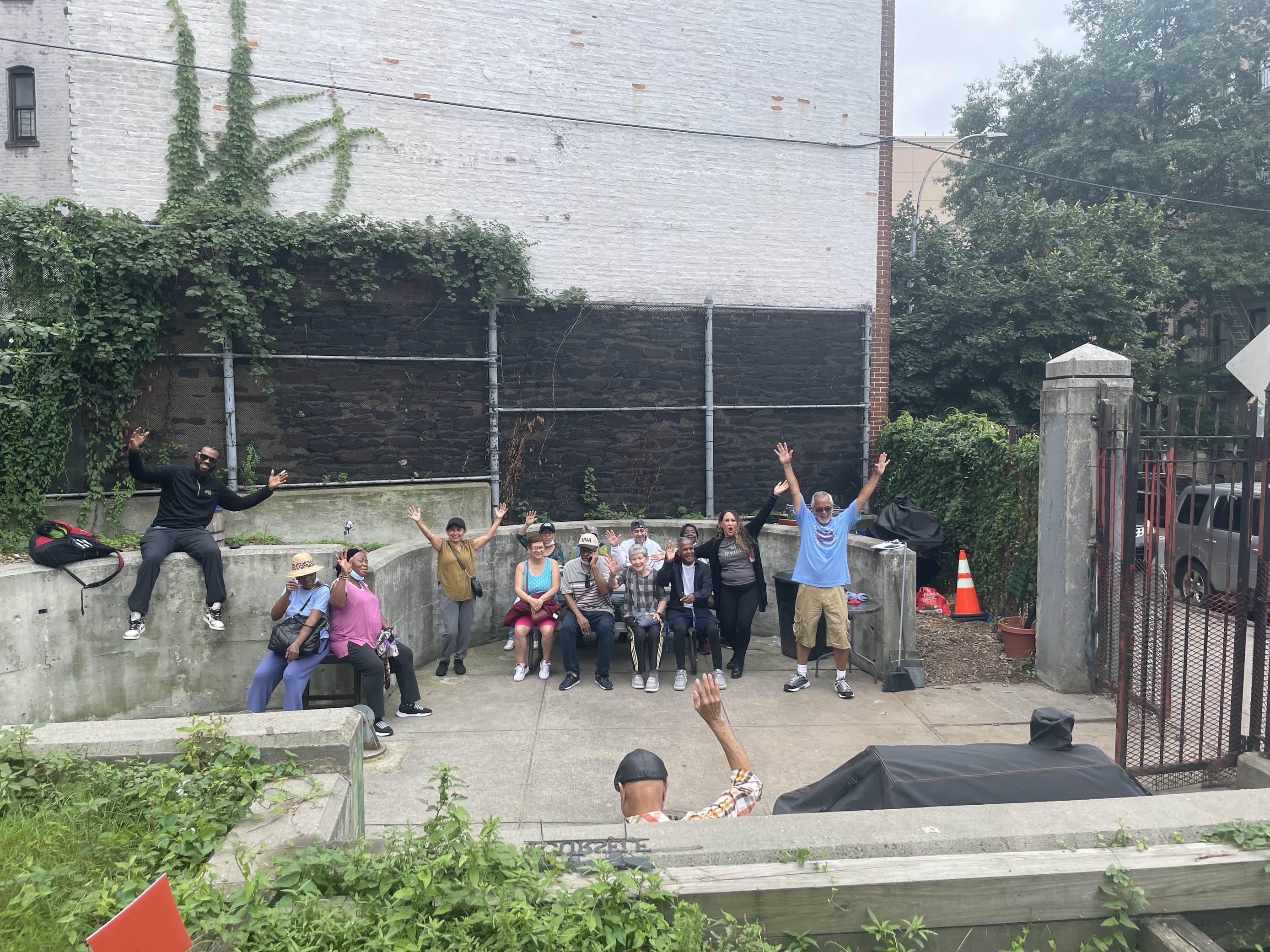 Diverse community members with raised arms celebrating in an urban garden space