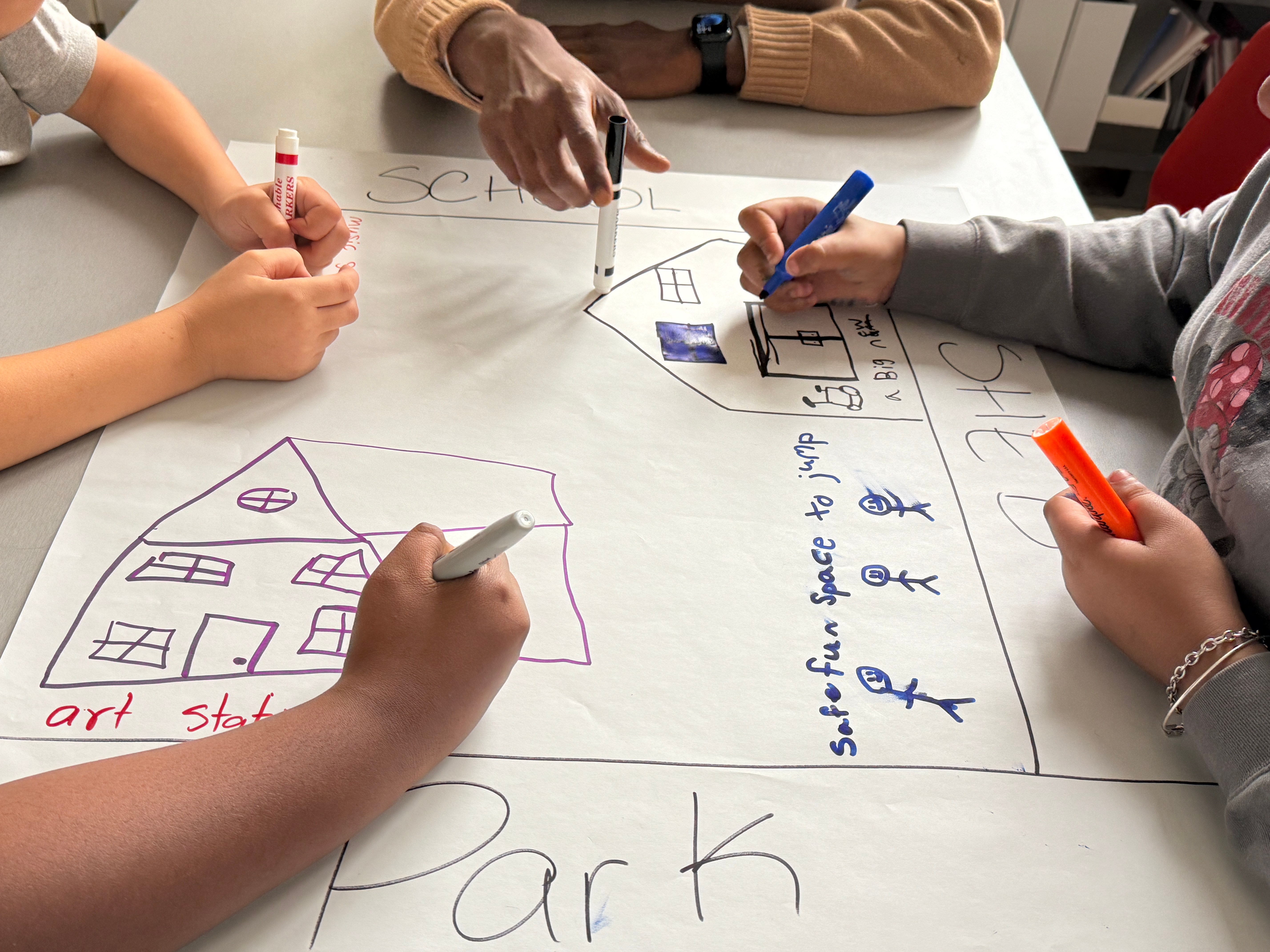 Students collaboratively designing public spaces with markers and paper