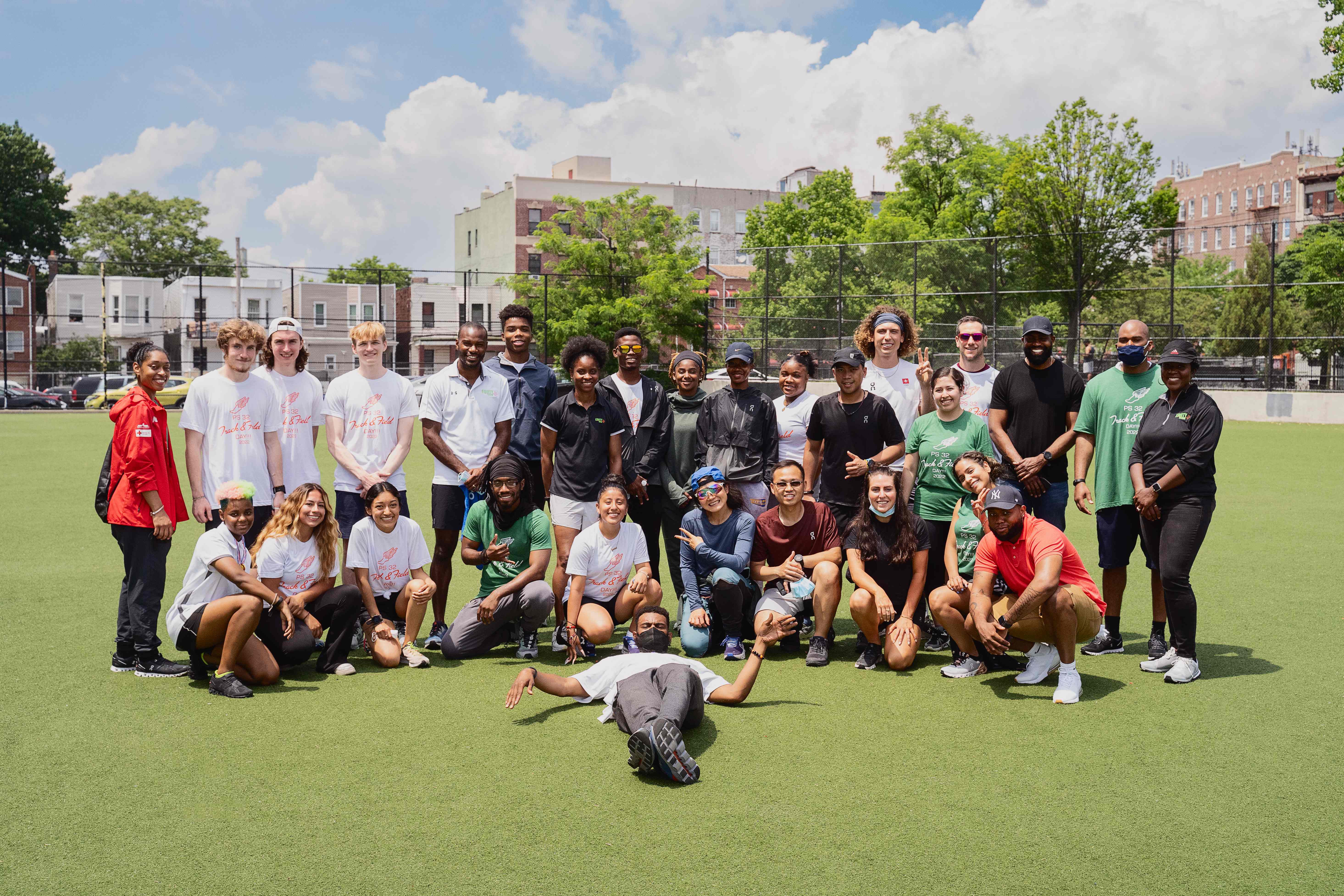 Diverse group of program participants and staff gathered on a sports field