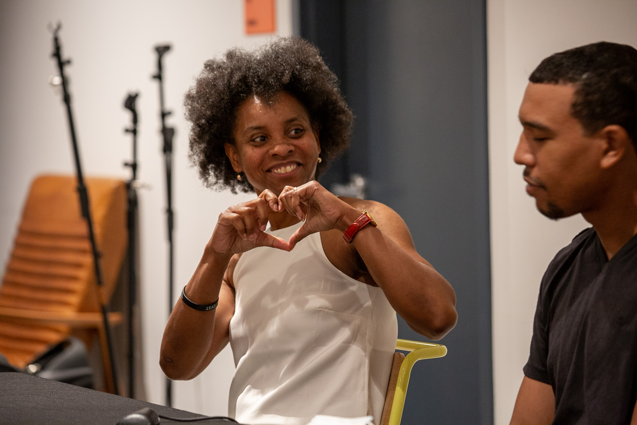 Woman making heart shape with hands during community engagement session
