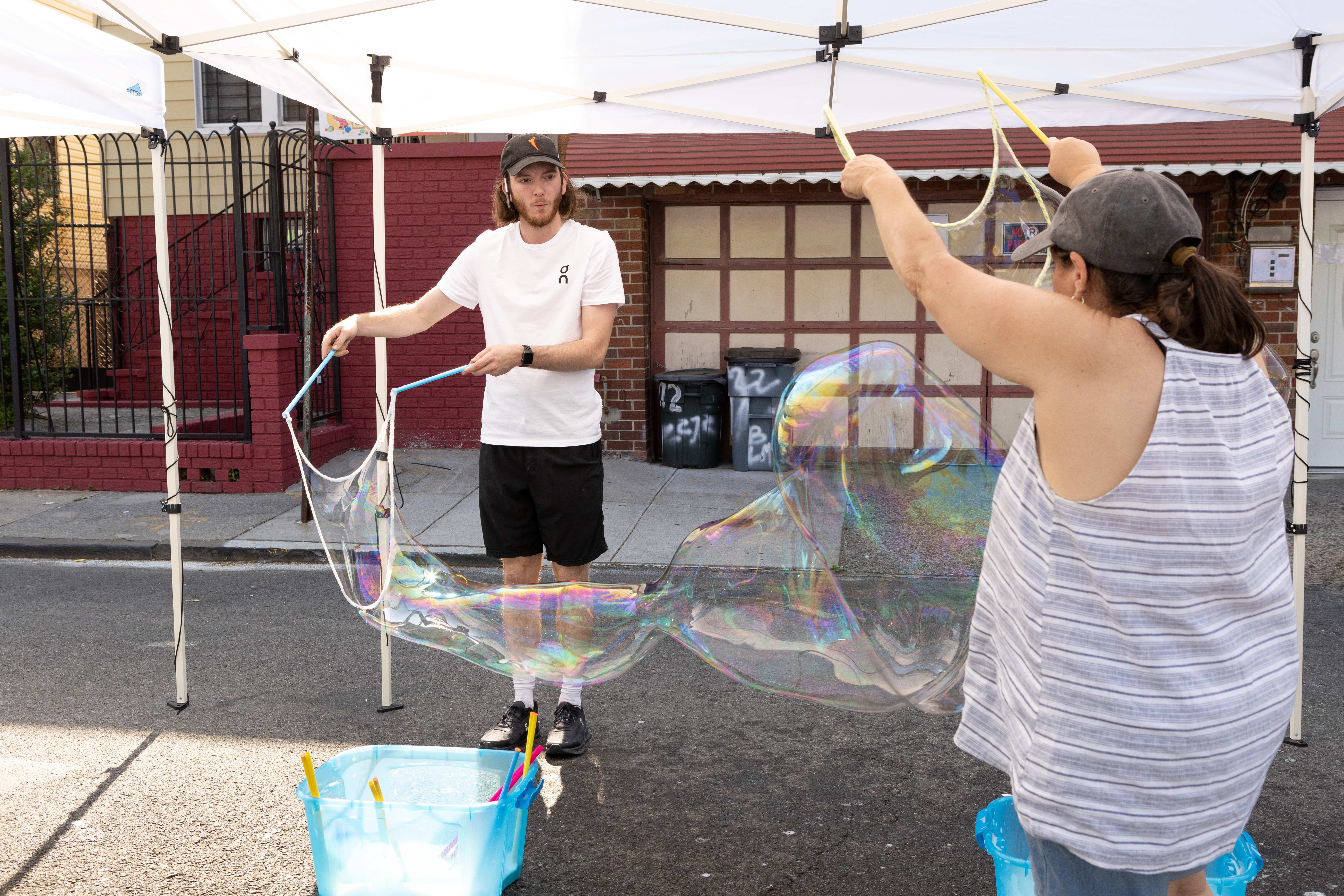 People creating giant soap bubbles at a community event