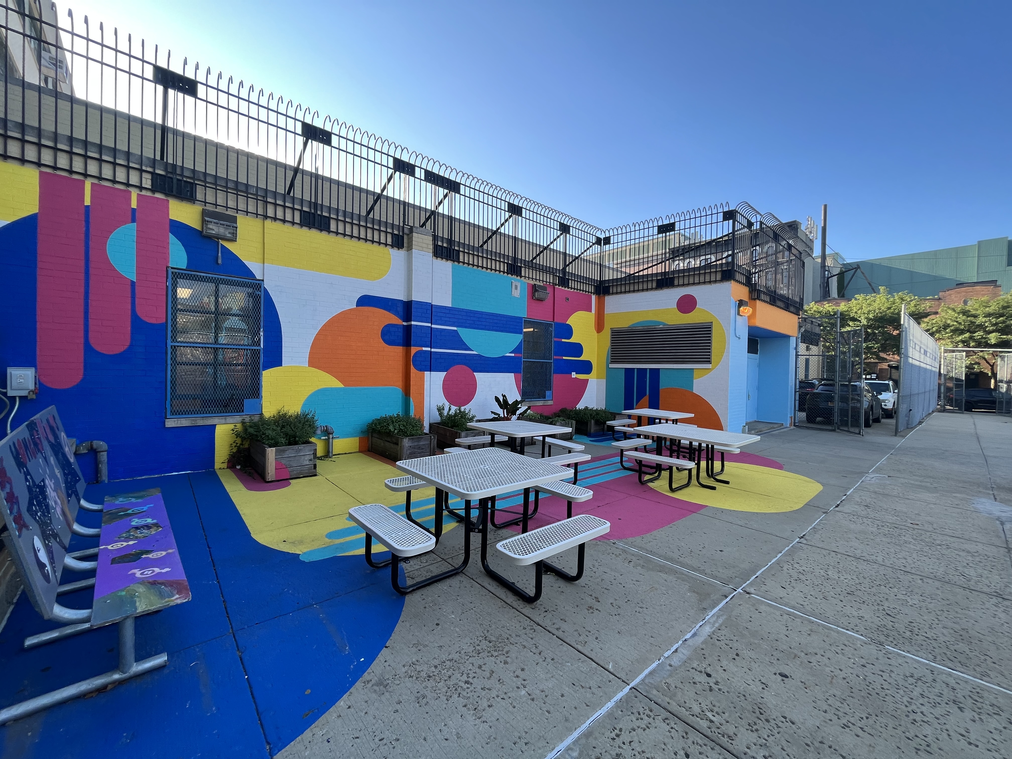 Colorful outdoor school space with vibrant murals and picnic tables