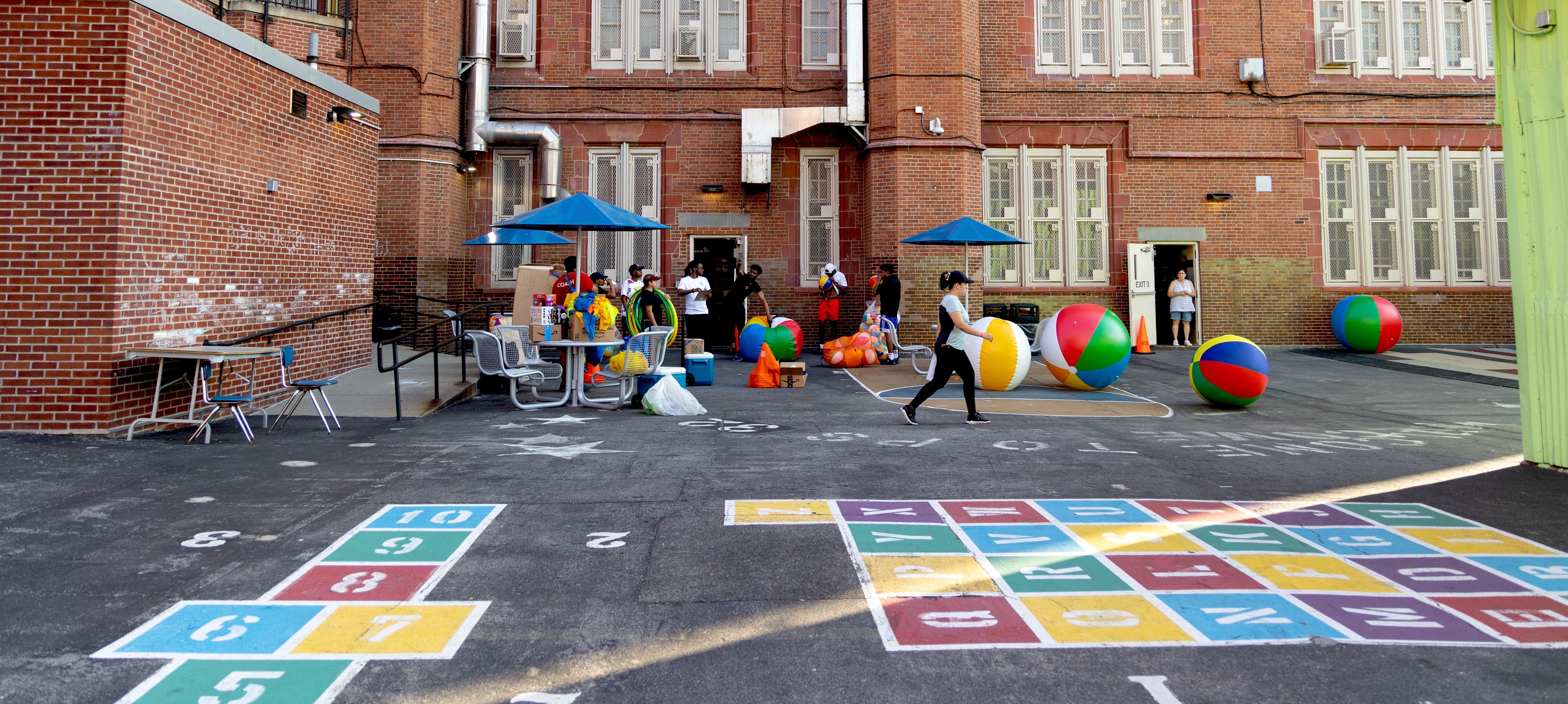School playground with colorful hopscotch patterns and beach balls