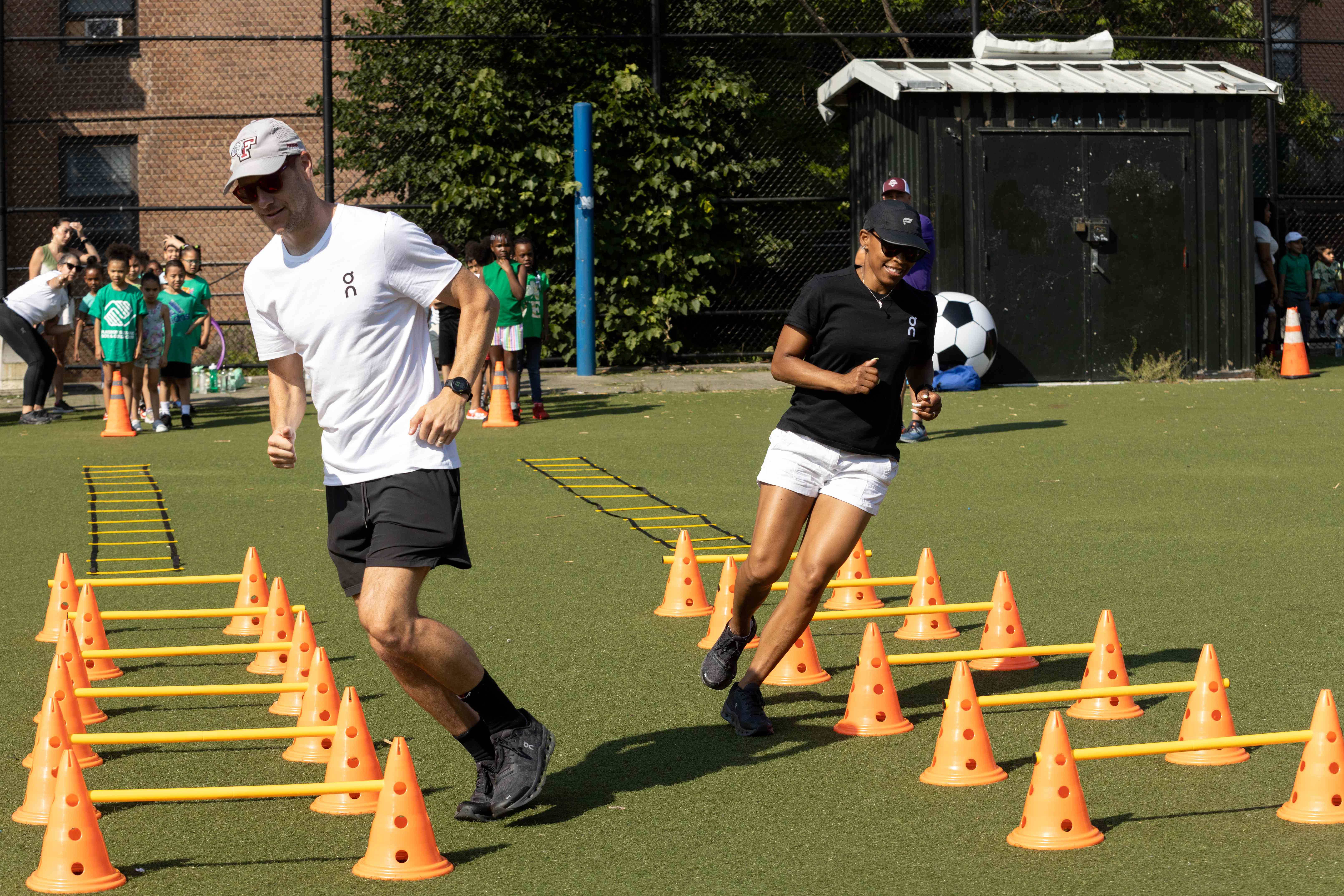 Instructors demonstrating agility drills with orange cones