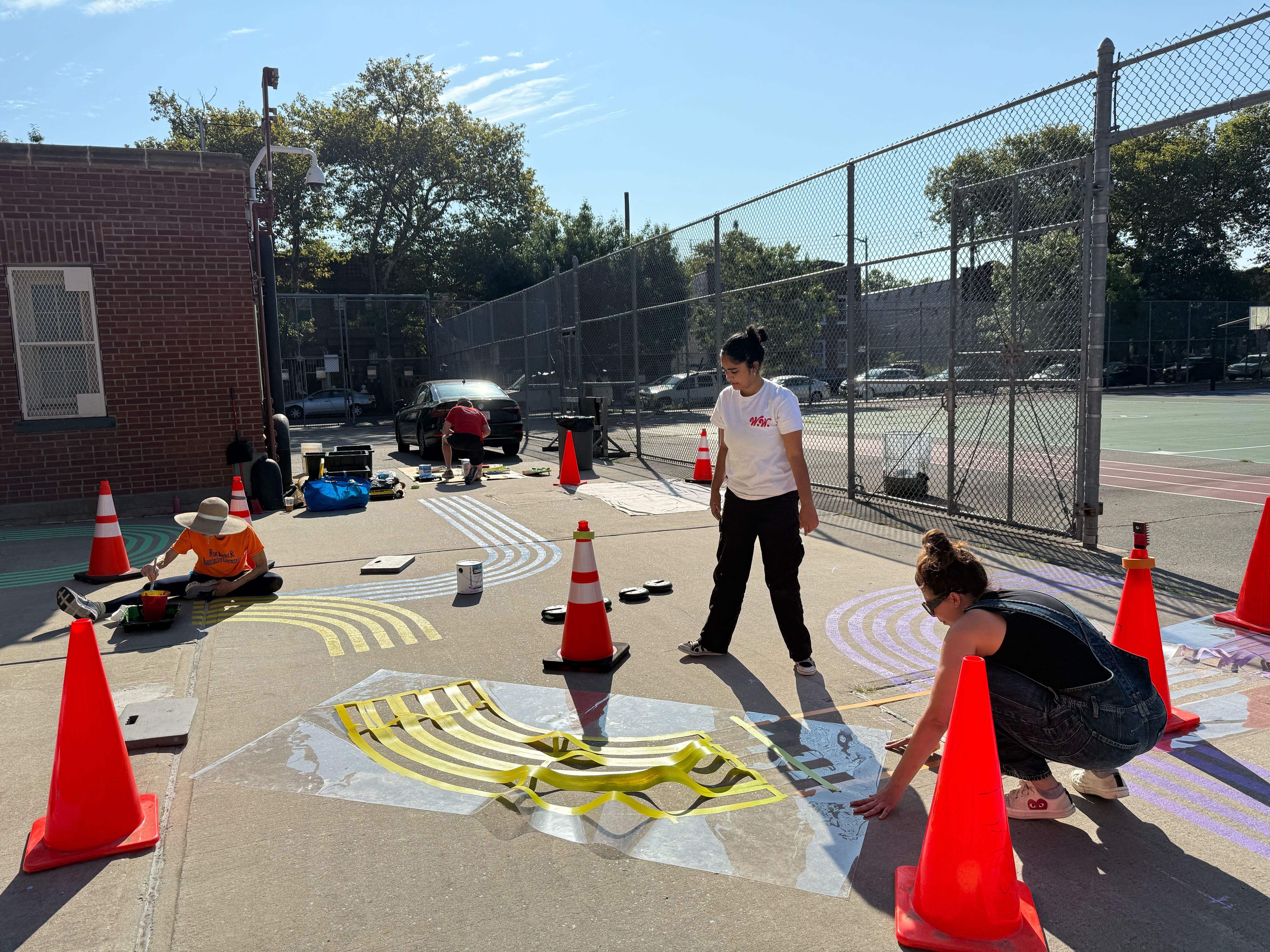 Community members painting colorful patterns on playground surface